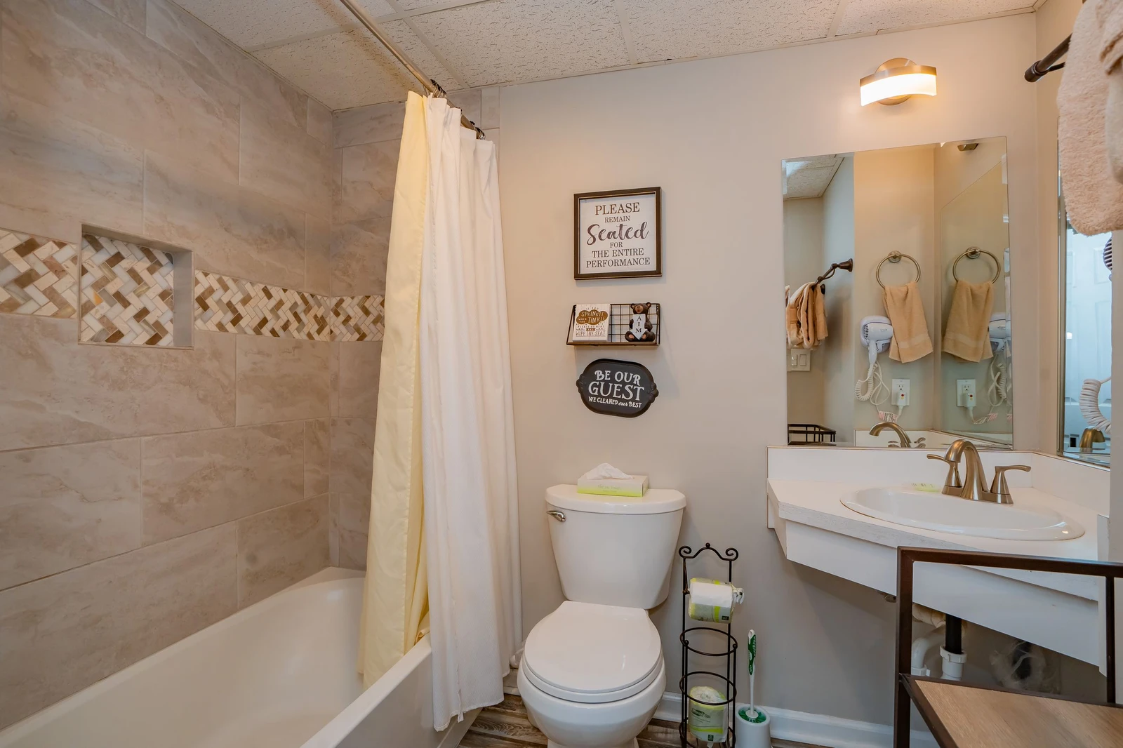 Refresh in your private bathroom featuring a tiled tub-shower combo, modern vanity with warm bronze fixtures, and thoughtful guest touches that make you feel right at home.
