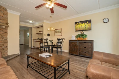 Step into a welcoming living and dining space where warm tones and comfortable furnishings invite you to unwind. Gather around the dining table for meals or relax on the plush sofa after a day of adventure.