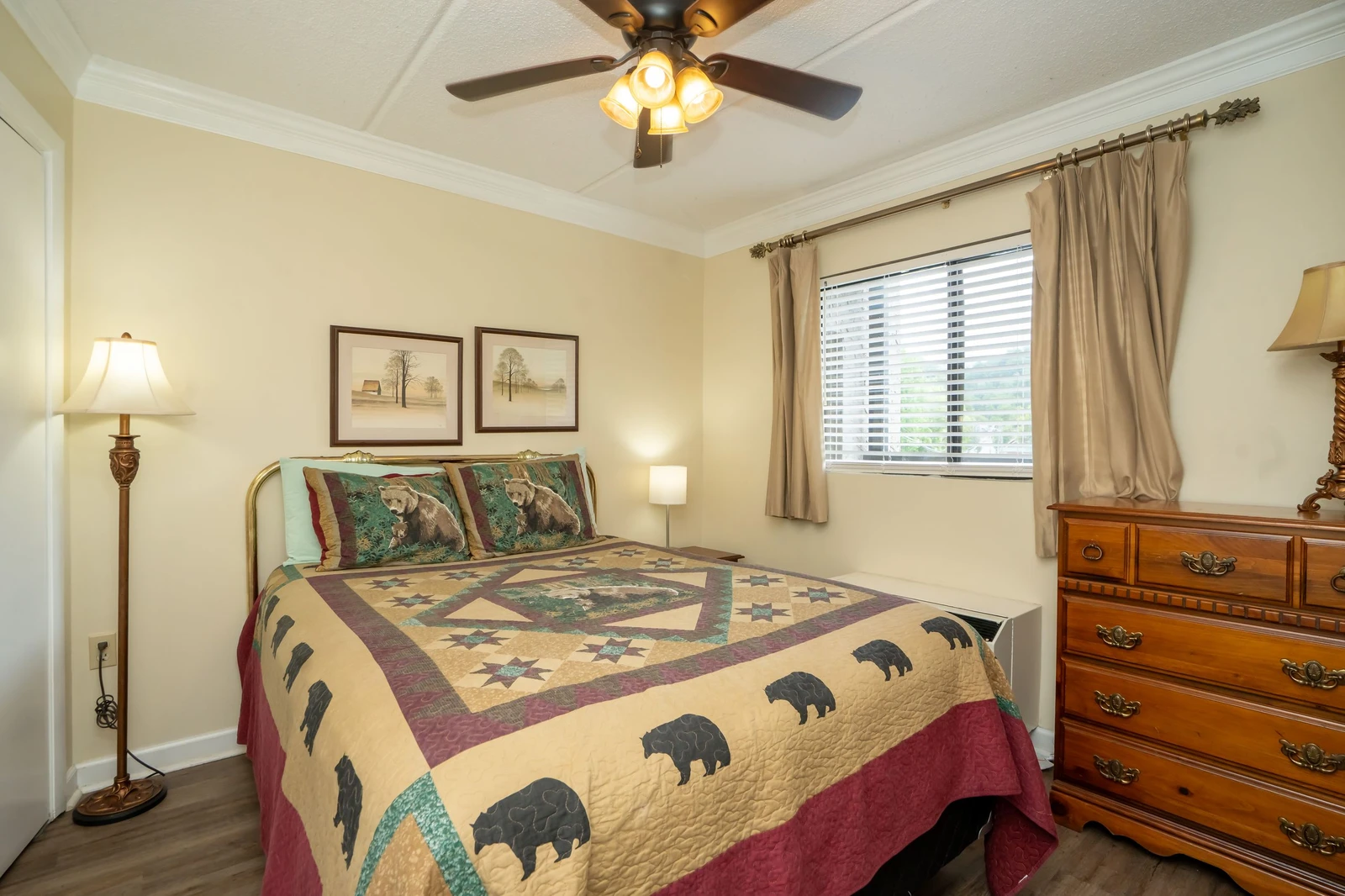 Settle into this cozy bedroom where warm wood tones and rustic charm welcome you. The gentle breeze from the ceiling fan and natural light from the window promise restful mountain mornings.
