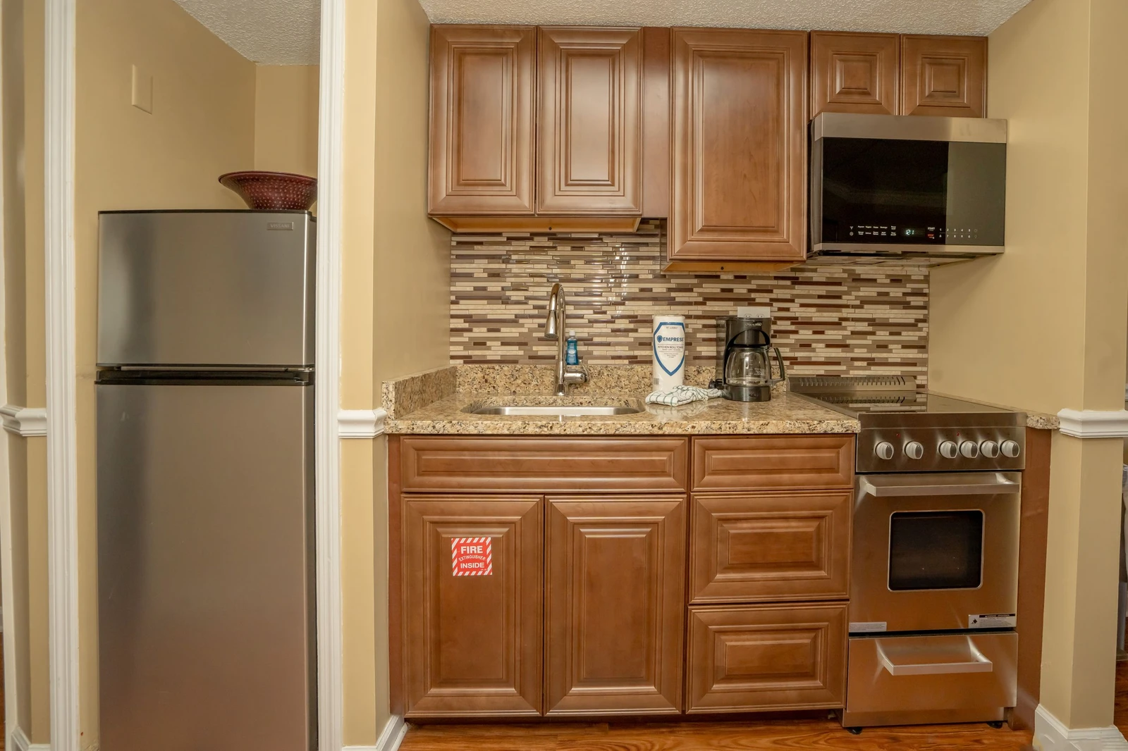Your fully equipped kitchen features granite countertops, stainless appliances, and a stylish tile backsplash—everything you need to prepare meals and feel at home during your stay.