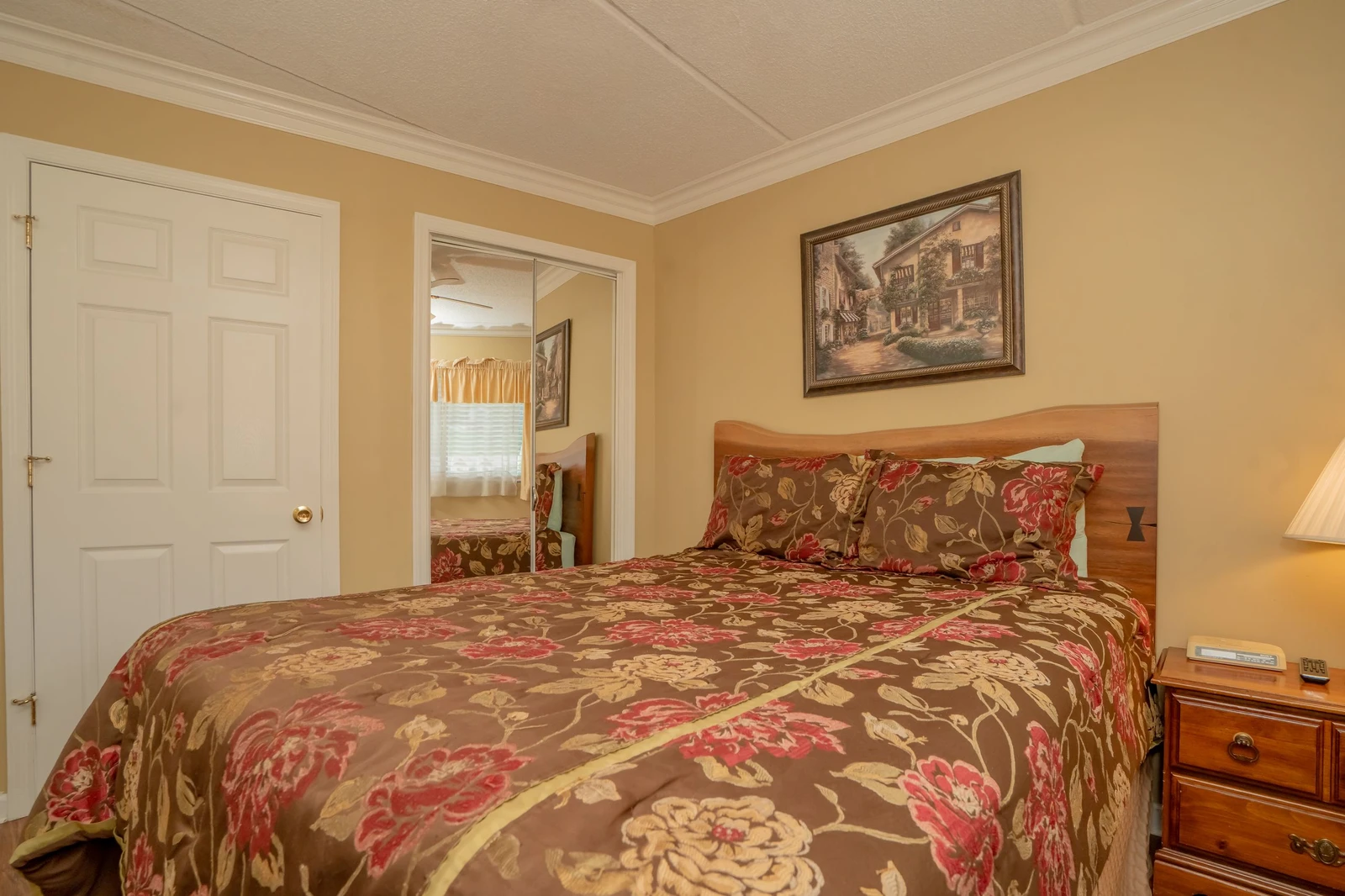 Settle into your peaceful bedroom retreat with warm colors and comfortable bedding that invites restful sleep.