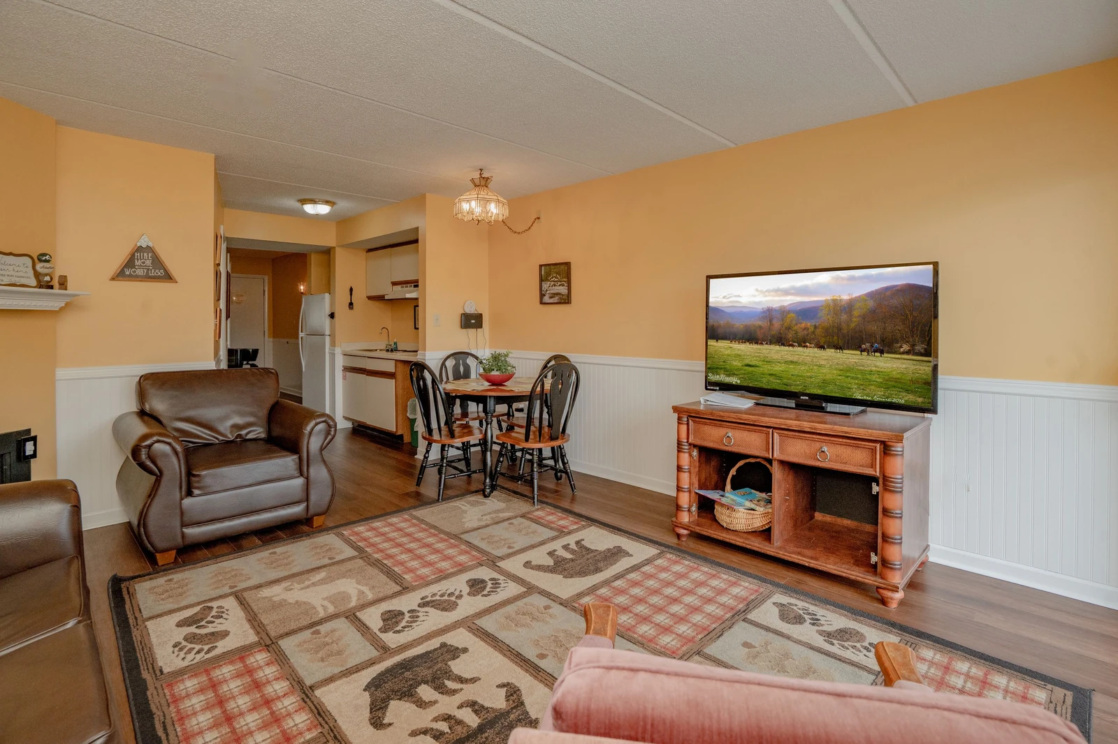 Settle into your cozy living area where warm tones and comfortable seating invite you to relax after a day of adventure. Your open layout flows seamlessly into a dining space and kitchen, perfect for easy living.