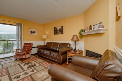 Settle into your cozy living space with plush leather seating and mountain views from the balcony. Warm tones and rustic touches create a welcoming retreat after your adventures.