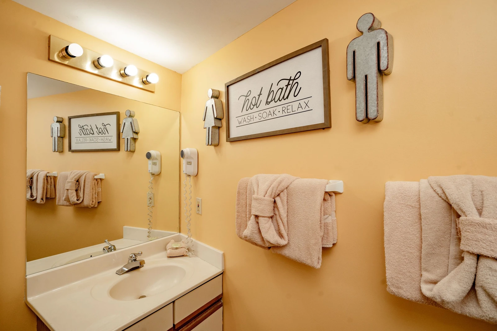 Bright and cheerful bathroom with plush towels ready for your arrival. Warm lighting and thoughtful touches make freshening up a pleasure.