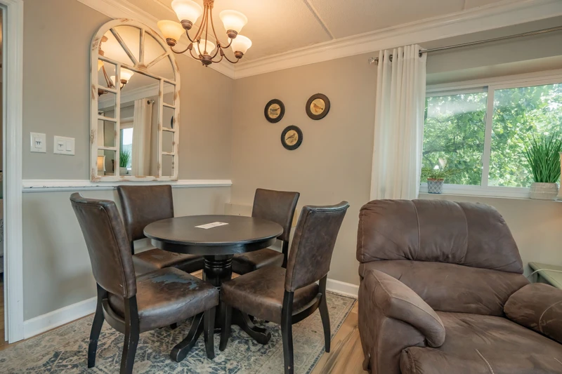 Gather around the dining table and sink into the plush sofa—your space to share meals, conversation, and laughter with lush garden views streaming through the window.