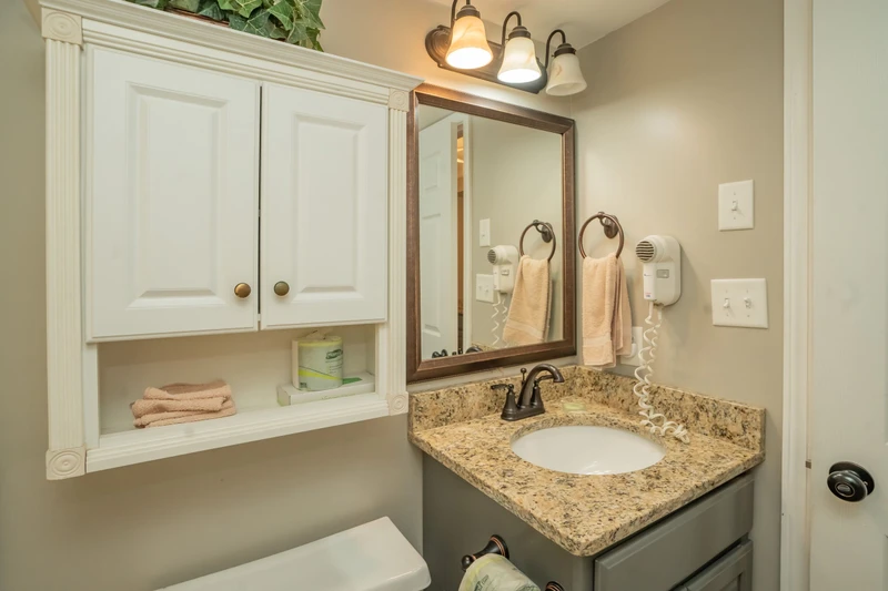 Step into your private bathroom, where soft lighting, fresh towels, and thoughtful touches like a wall-mounted hairdryer create a welcoming retreat after a day of exploring.
