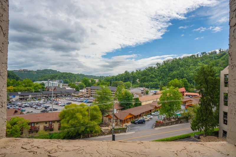 Sweeping views over the bustling town center below, framed by lush green hills and a vibrant blue sky. Watch the world go by from this elevated vantage point.