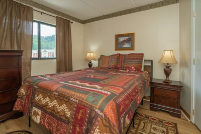 Rest easy in your inviting bedroom, where earthy tones and mountain-inspired décor create a cozy retreat. Natural light streams through your window, revealing the peaceful neighborhood just outside.