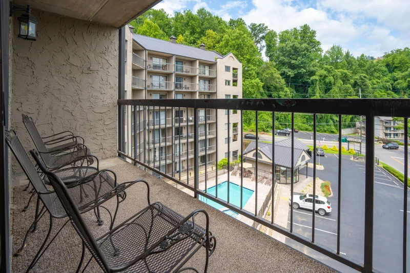 Your private balcony overlooks the pool and lush green surroundings, with comfortable seating perfect for morning coffee or evening relaxation.
