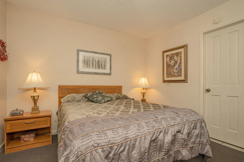 Your peaceful bedroom features warm wood tones and soft bedside lighting, creating the perfect cozy retreat after a day of adventure.