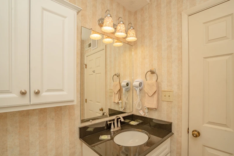 Your private bathroom features warm lighting, a polished granite vanity, and thoughtful touches like mounted hair dryers—everything you need to refresh and get ready comfortably.