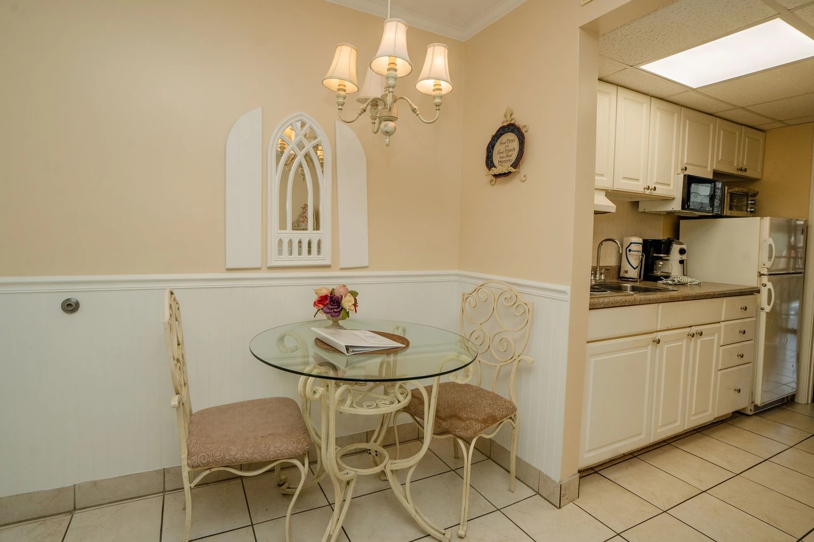 Step into your charming dining nook, where a glass-top bistro table invites you to enjoy morning coffee or romantic dinners beneath an elegant chandelier. Your fully equipped kitchenette makes preparing meals a breeze.