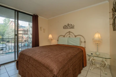 Your peaceful bedroom retreat features warm lighting and opens to a private balcony where you can unwind with views of the surrounding neighborhood.