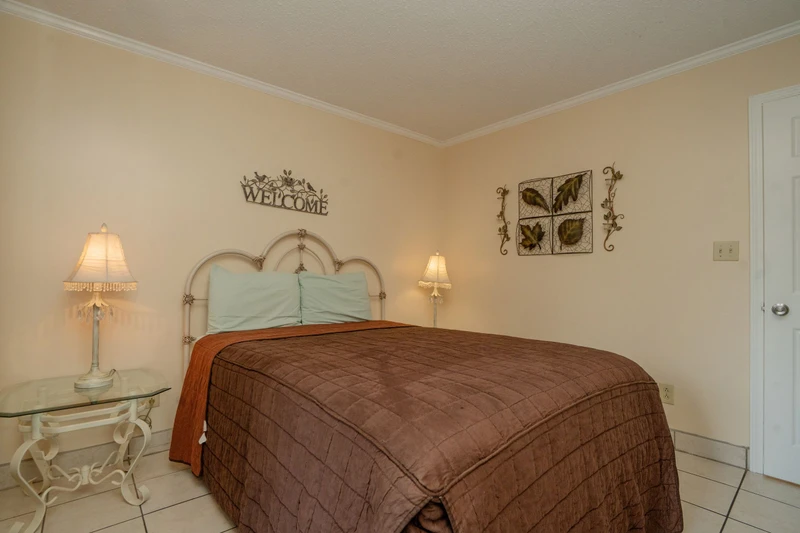 Slip into your peaceful retreat with a welcoming bedroom dressed in warm earth tones and soft bedside lighting that sets the mood for relaxation.