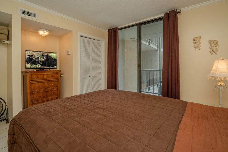 Rest easy in this inviting bedroom with soft lighting, cozy linens, and a private balcony where you can step out for fresh air.