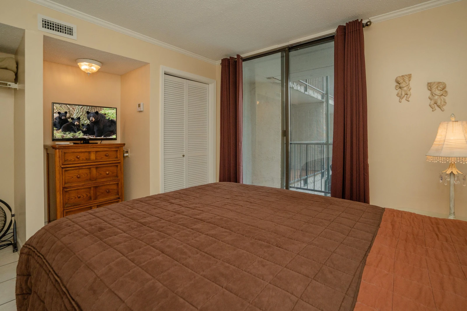 Rest easy in this inviting bedroom with soft lighting, cozy linens, and a private balcony where you can step out for fresh air.