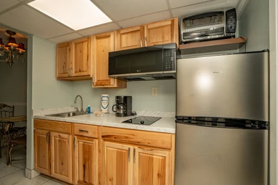 Your fully equipped kitchenette features warm wood cabinetry, stainless steel appliances, and everything you need to prepare meals during your stay.