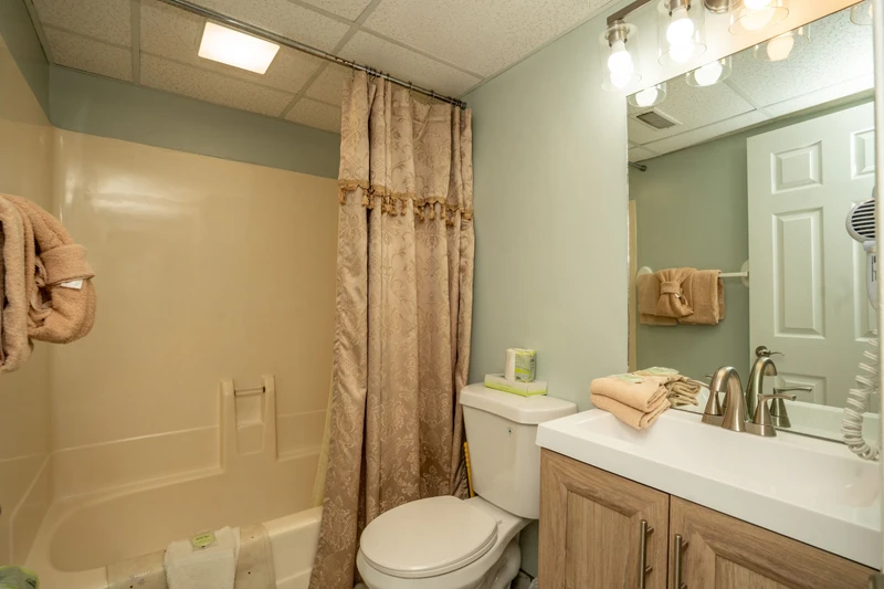 Step into your private bathroom featuring a full tub-shower combo, fresh towels, and plenty of vanity space to get ready for the day.