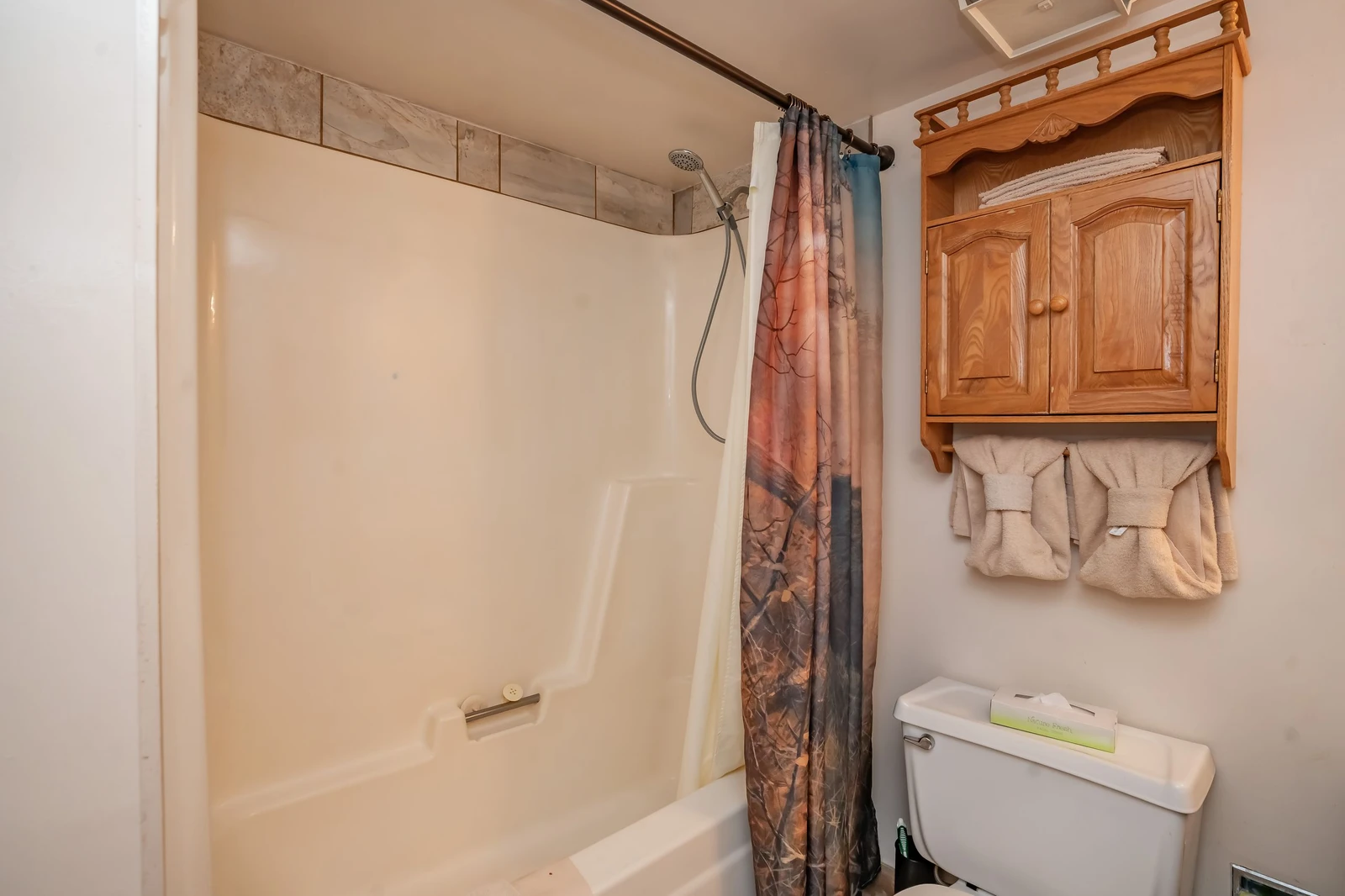 Freshen up in your private bathroom with a spacious shower-tub combo and warm wood cabinetry for storing your essentials.