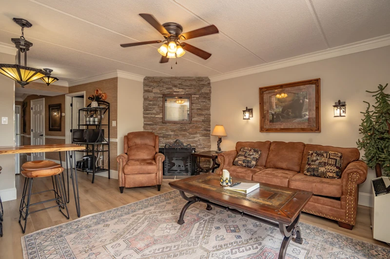 Settle into your cozy living room, where rich leather seating and rustic stone fireplace create the perfect retreat after a day exploring. Ceiling fan keeps you comfortable year-round.