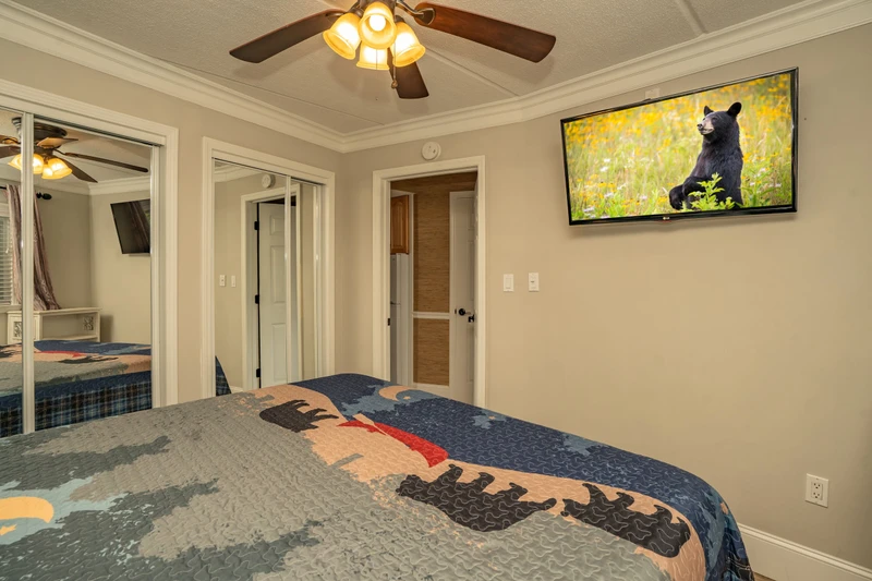 Drift off under soft lighting in this cozy bedroom with comfortable bedding, a ceiling fan to keep you cool, and a TV ready for your favorite shows.