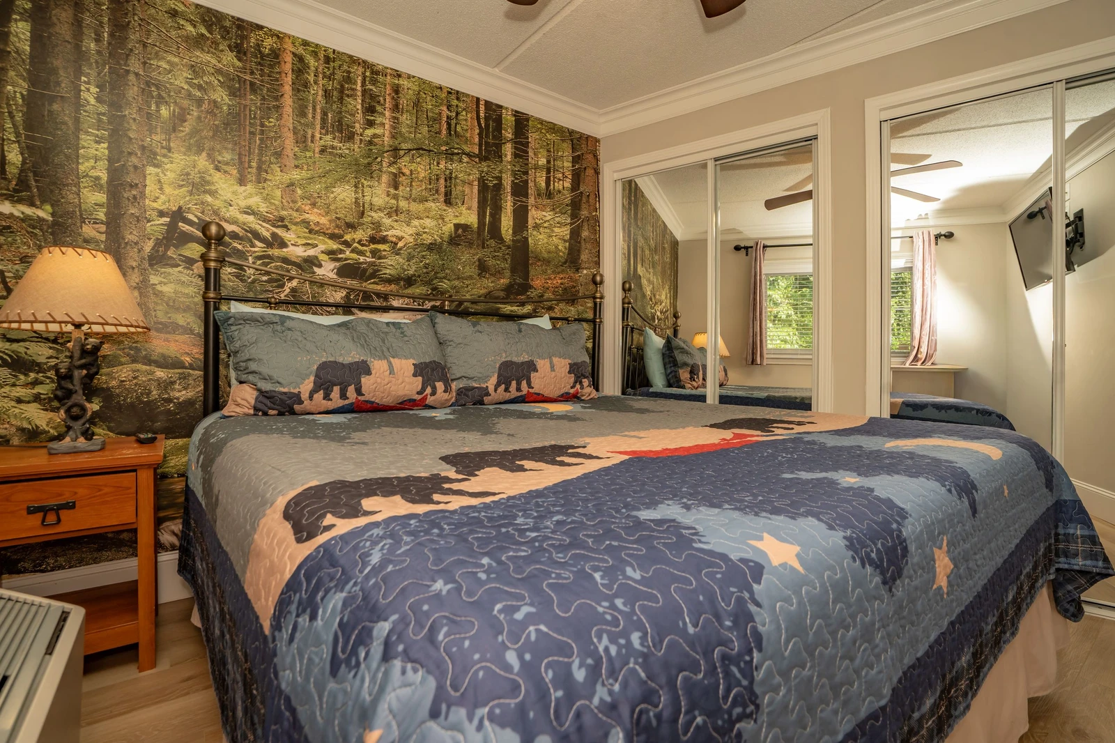 Cozy woodland retreat where nature meets comfort. A forest mural and plush bear-motif bedding create a serene sanctuary, while warm wood accents and soft lighting offer the perfect respite after mountain adventures.