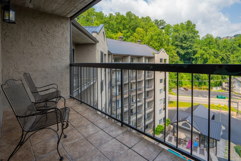 Your balcony overlooks lush hillside scenery and nearby shops, creating a peaceful mountain getaway with convenience just steps away.