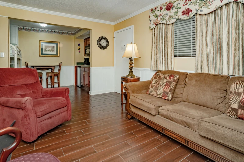 Settle into plush seating in your spacious living area, where warm wood-look floors and elegant furnishings create the perfect spot to unwind after a day of exploring.