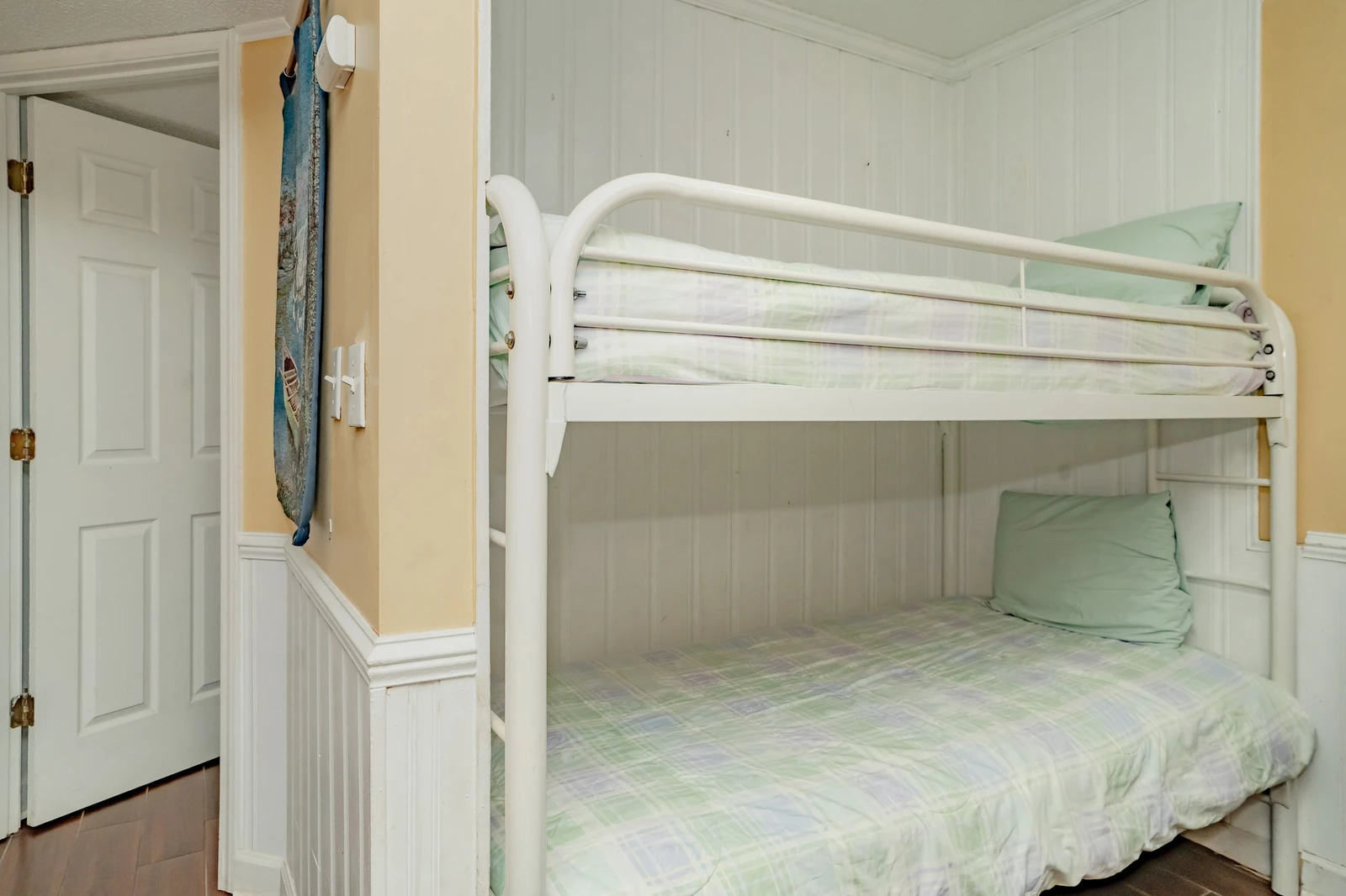 Cozy bunk beds with soft plaid linens create a perfect space for kids or extra guests in your coastal getaway.