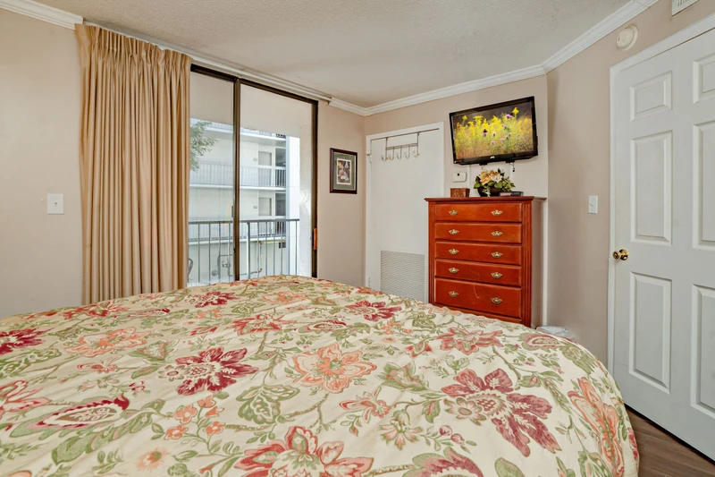 Sink into a floral-dressed bed with a soft breeze from your balcony. Your cherry wood dresser holds everything you need, while wall art adds charm to your peaceful retreat.