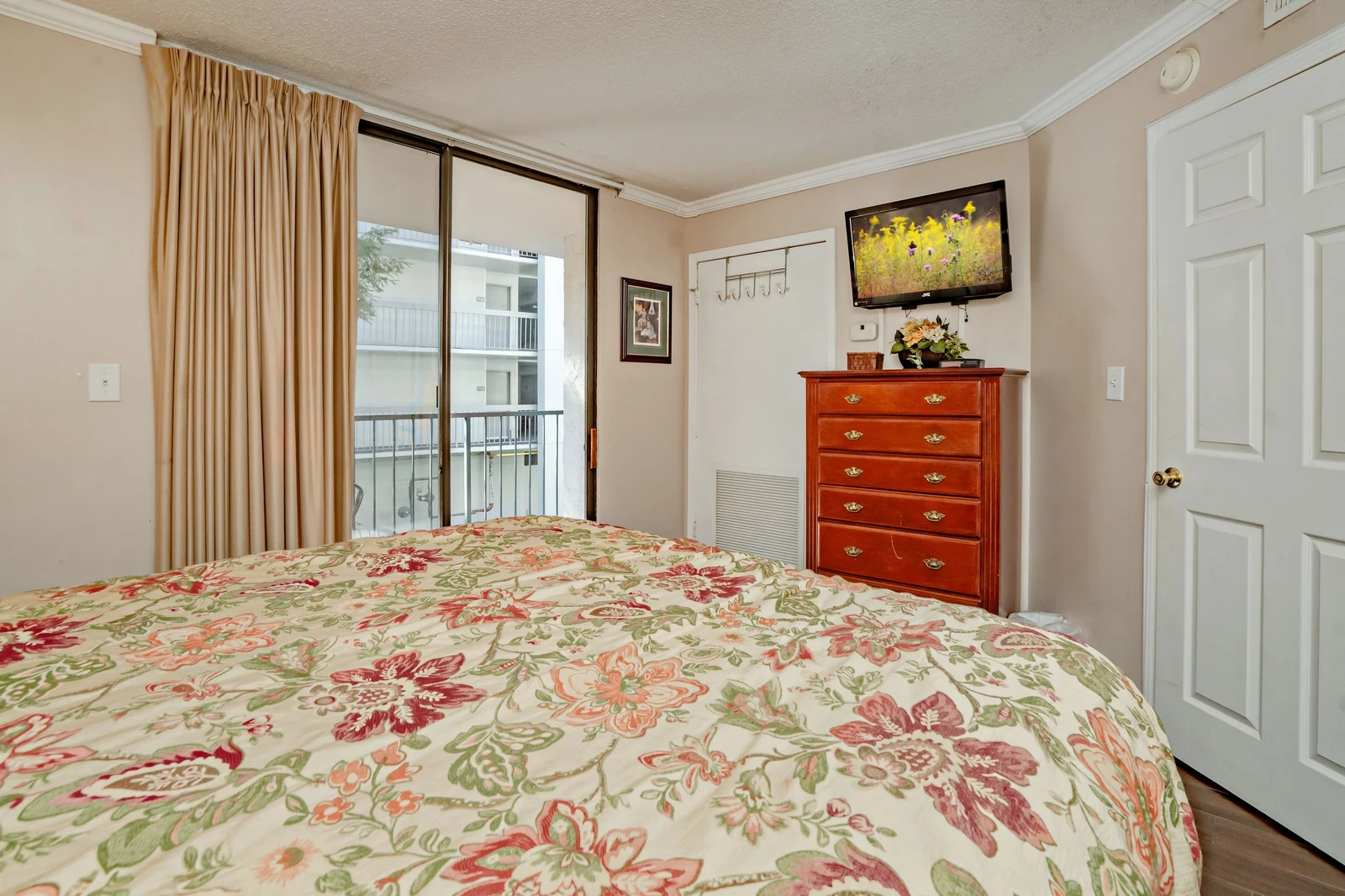 Sink into a floral-dressed bed with a soft breeze from your balcony. Your cherry wood dresser holds everything you need, while wall art adds charm to your peaceful retreat.