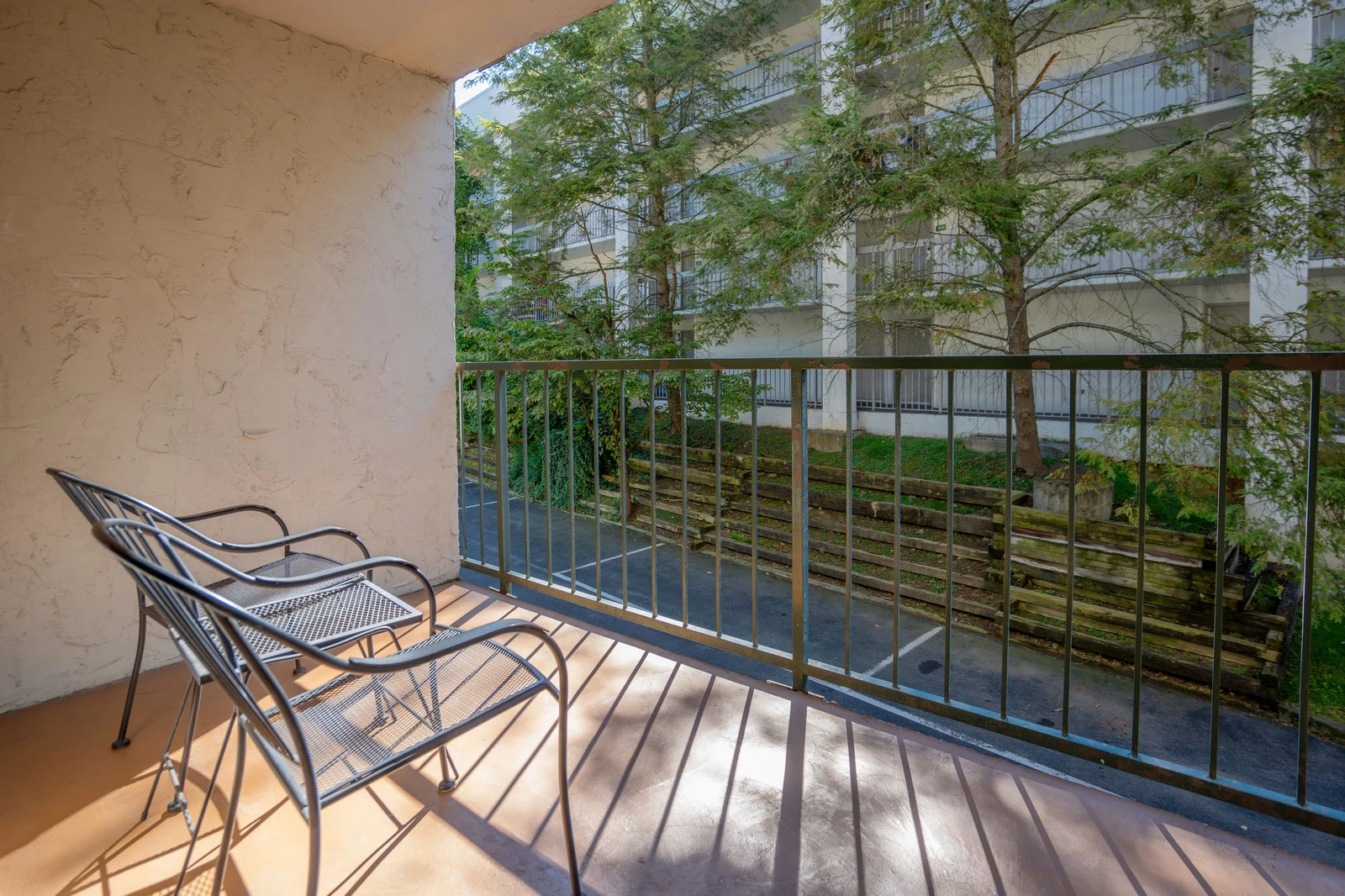 Your private balcony overlooks greenery and courtyards, perfect for morning coffee or unwinding as sunlight filters through the trees.