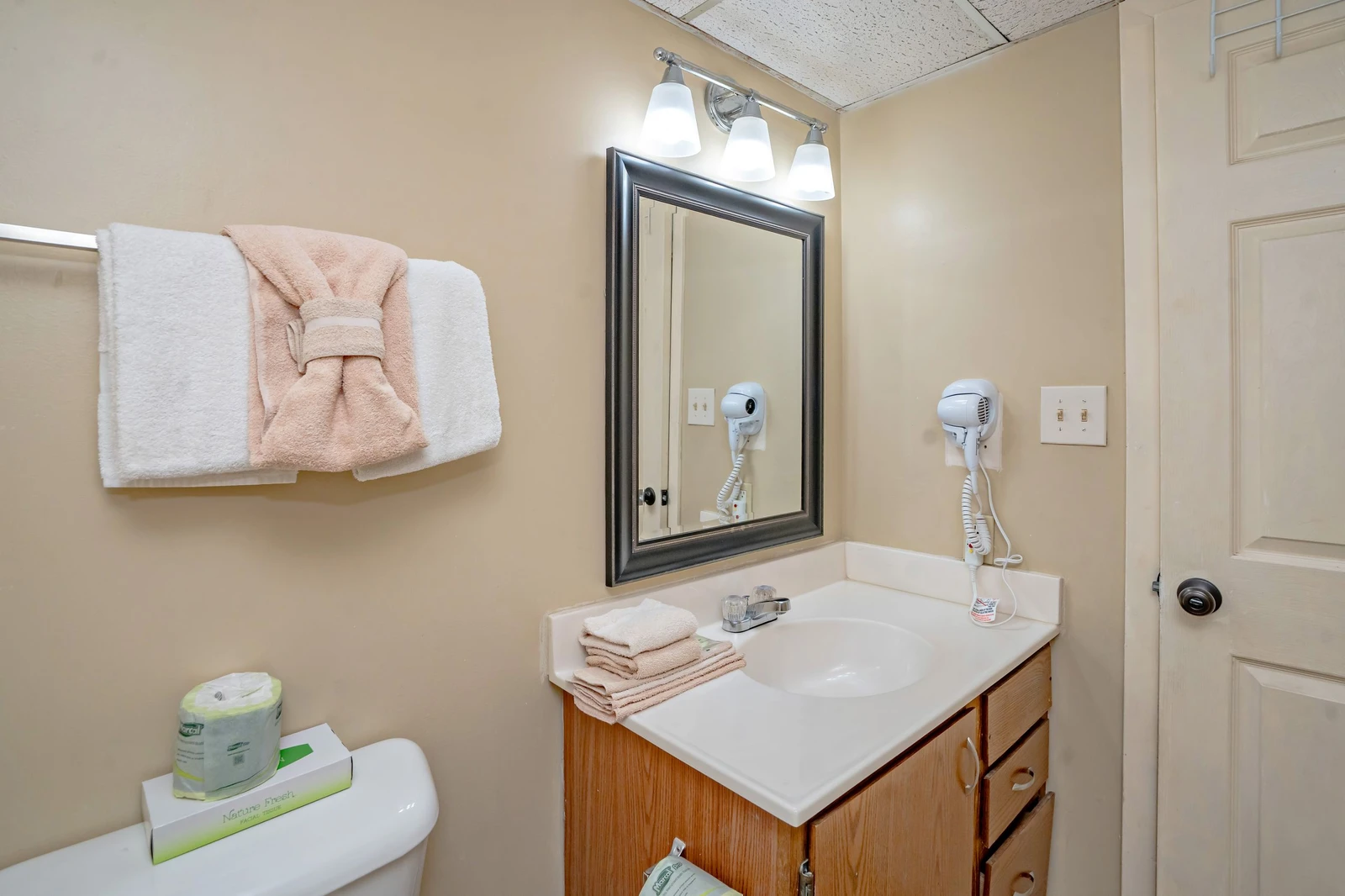 Step into your private bathroom where fresh towels and a hair dryer await your arrival. The well-lit vanity makes morning routines effortless and comfortable.