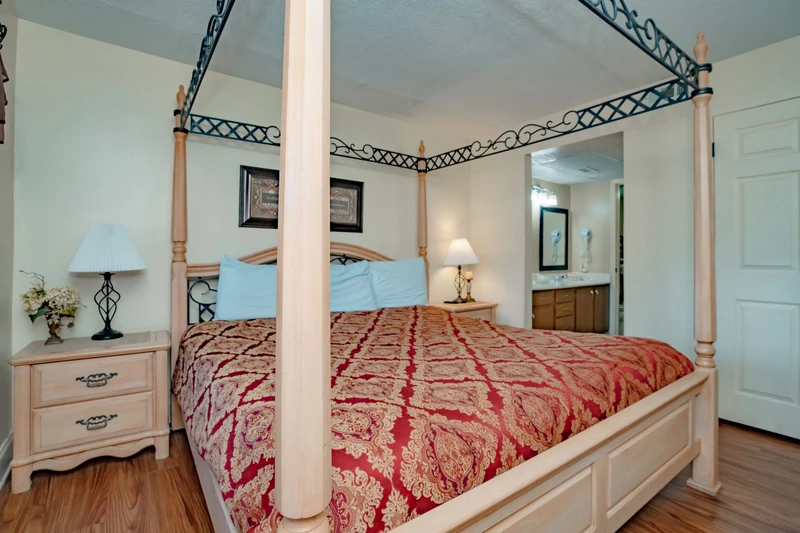 Unwind in your serene bedroom, where a stately four-poster bed draped in elegant textiles invites restful nights beneath a soft turquoise ceiling.