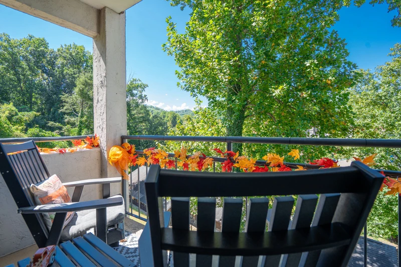 Step onto your private balcony and breathe in the fresh mountain air. Bright flowers frame stunning views of lush forest and distant peaks—your peaceful retreat awaits.