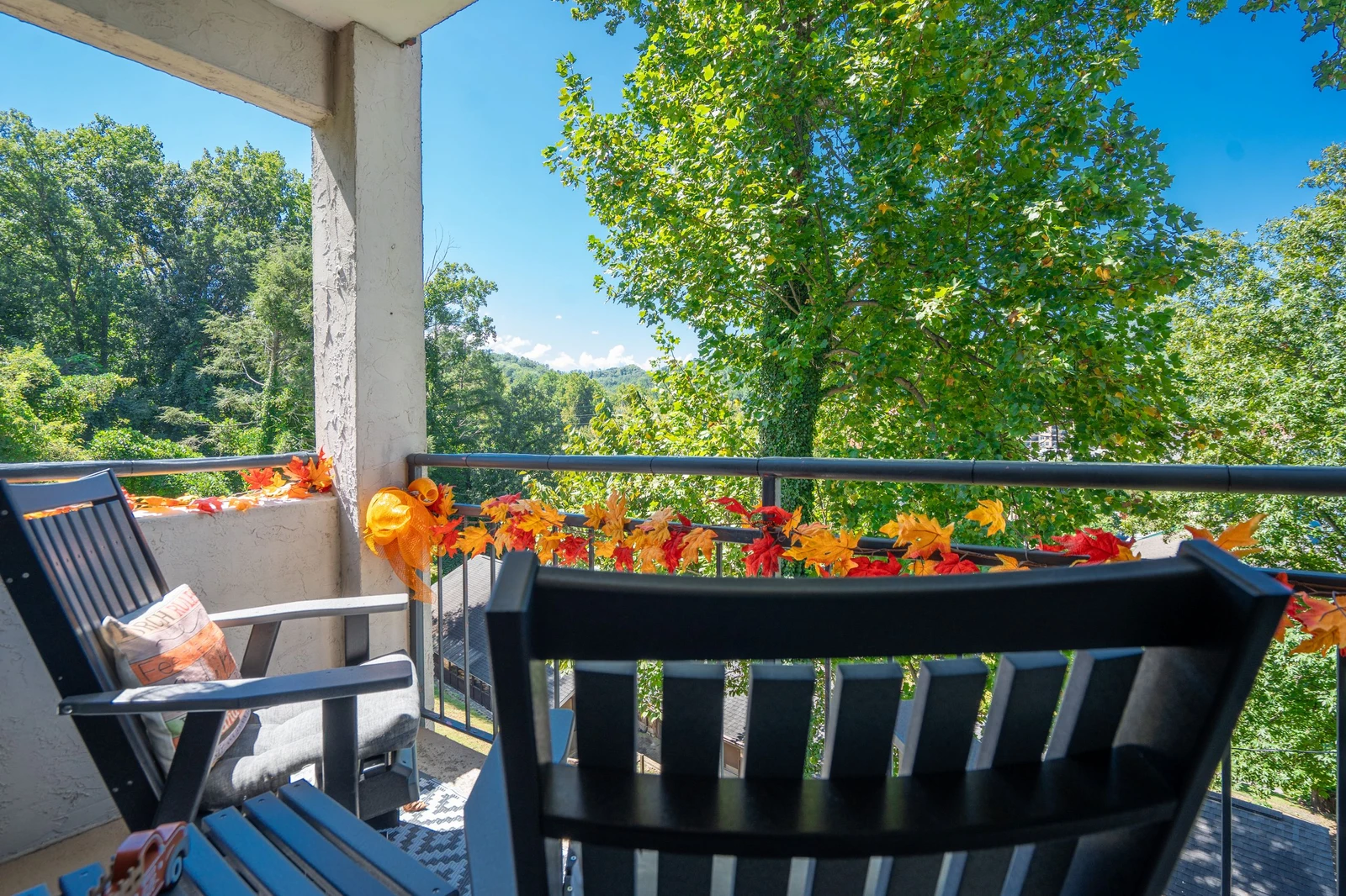 Step onto your private balcony and breathe in the fresh mountain air. Bright flowers frame stunning views of lush forest and distant peaks—your peaceful retreat awaits.