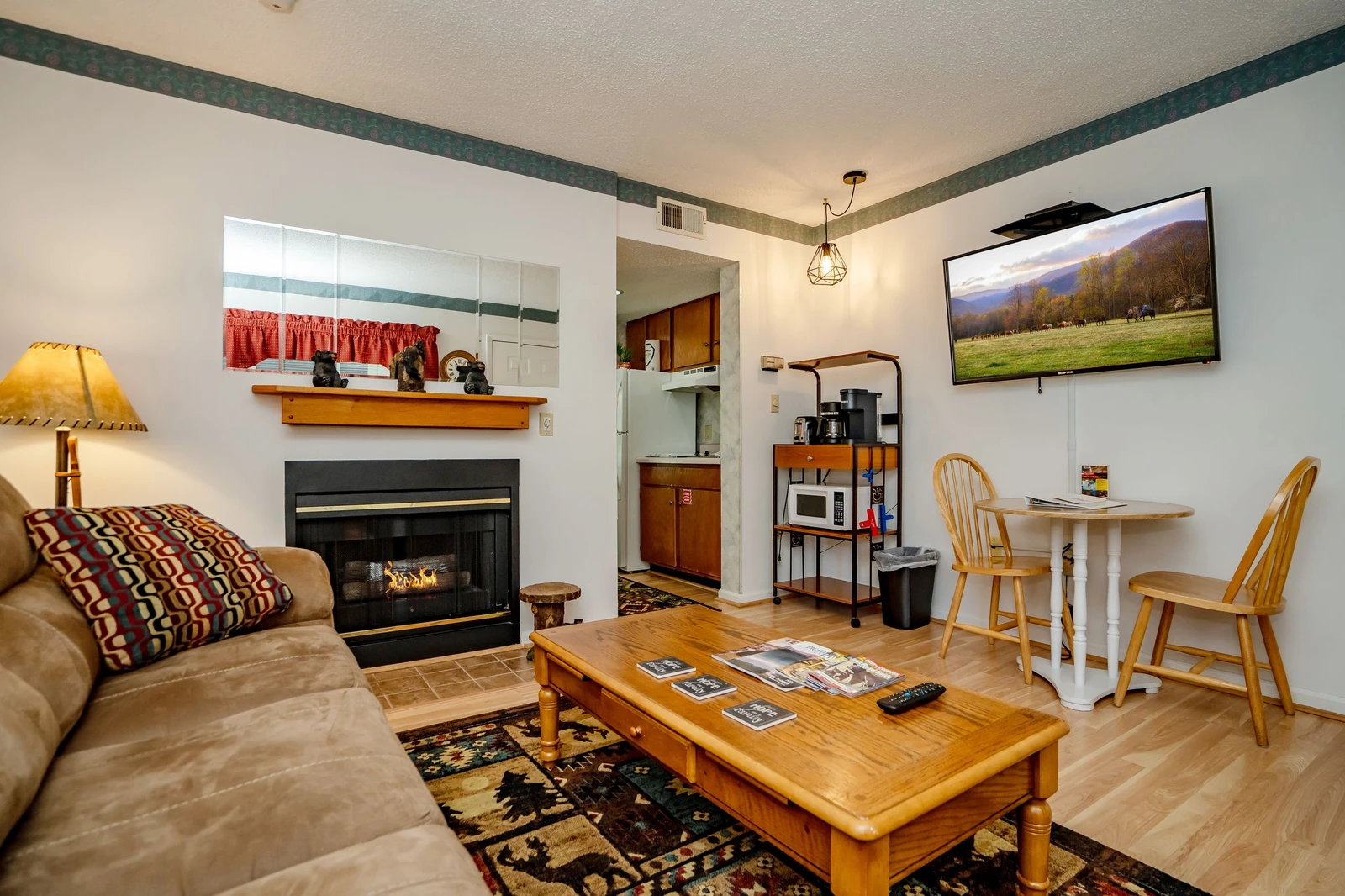 Relax in your cozy living space with a warm fireplace, comfortable seating, and a dining nook perfect for meals together. Your fully equipped kitchenette makes it easy to feel right at home.
