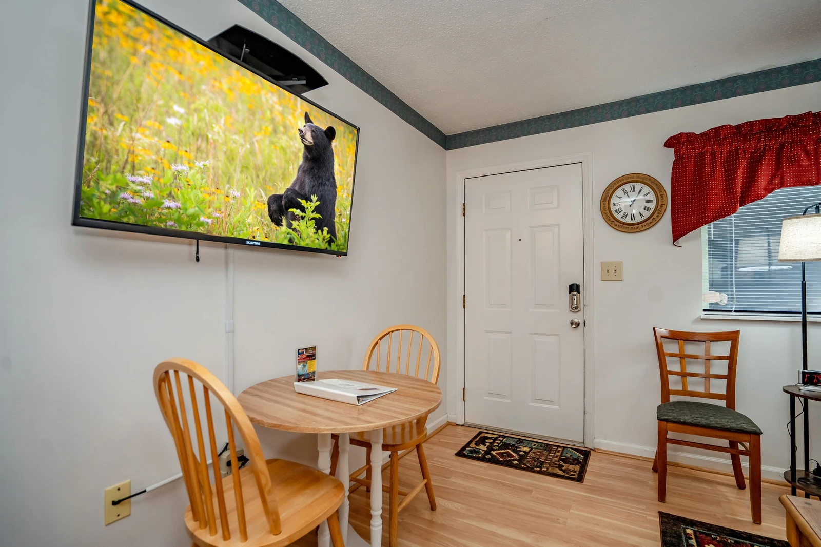 Your welcoming dining area features hardwood floors, a cozy table for meals or planning adventures, and a TV ready for your favorite shows after a day exploring.