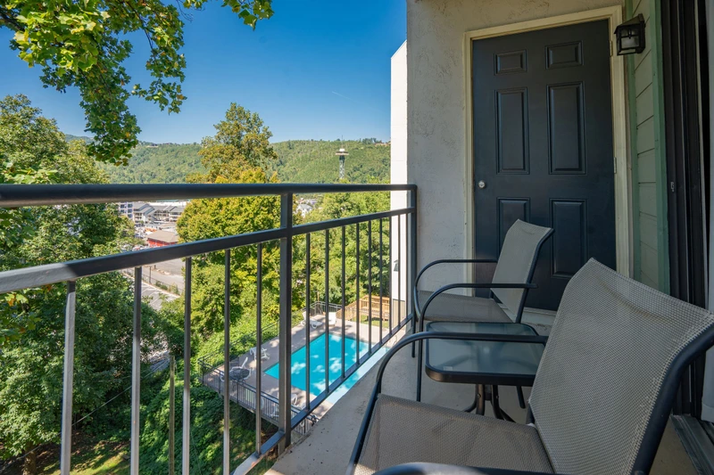 Settle into your private balcony with mountain and pool views—the perfect spot to sip morning coffee or unwind as the breeze rustles through the trees below.