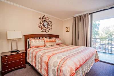 Drift off in your serene bedroom featuring a plush bed dressed in soft linens and a warm color palette. Natural light pours in from your private balcony, framing peaceful views of the surrounding neighborhood.