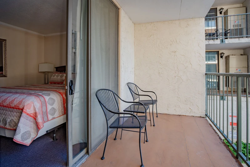 Step onto your private balcony where two cozy chairs await your morning coffee or evening unwind. This quiet outdoor space overlooks the surrounding area, offering you a peaceful retreat right outside your bedroom.