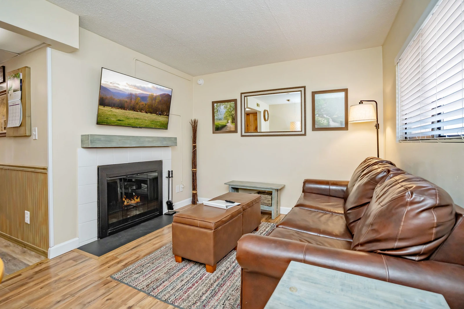 Settle into the leather sofa by the fireplace for a cozy evening. The bright living room offers comfortable seating and soft natural light, creating your perfect retreat after a day of adventure.