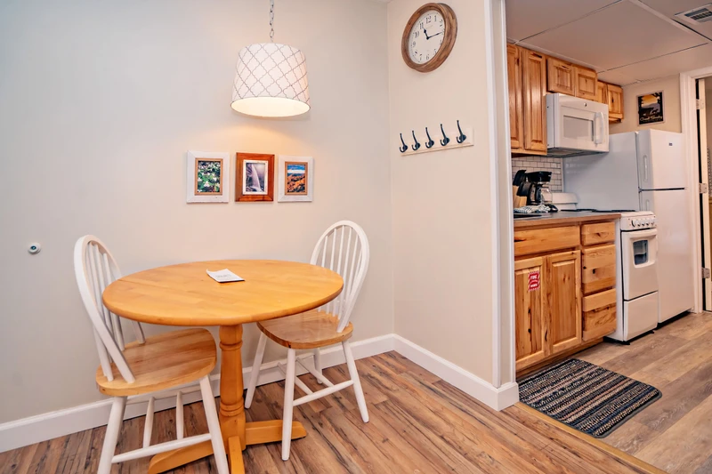 Step into your welcoming dining and kitchen area, where cozy meals and morning coffee await. The warm wood tones and bright pendant lighting create an inviting space to gather, cook, and unwind after your adventures.