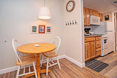Step into your welcoming dining and kitchen area, where cozy meals and morning coffee await. The warm wood tones and bright pendant lighting create an inviting space to gather, cook, and unwind after your adventures.