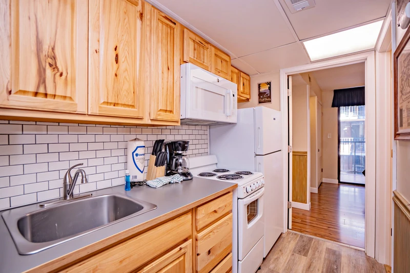 Your fully equipped kitchen features warm wood cabinetry, classic subway tile backsplash, and everything you need to prepare home-cooked meals during your stay.