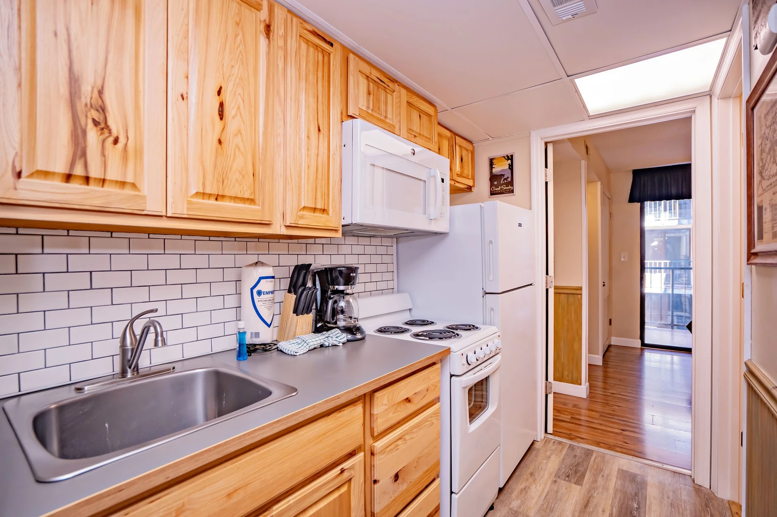 Your fully equipped kitchen features warm wood cabinetry, classic subway tile backsplash, and everything you need to prepare home-cooked meals during your stay.