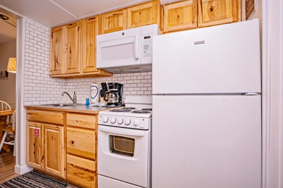 Your fully equipped kitchen features warm wood cabinetry, classic subway tile, and everything you need to prepare meals during your stay—including a stove, microwave, and coffee maker.
