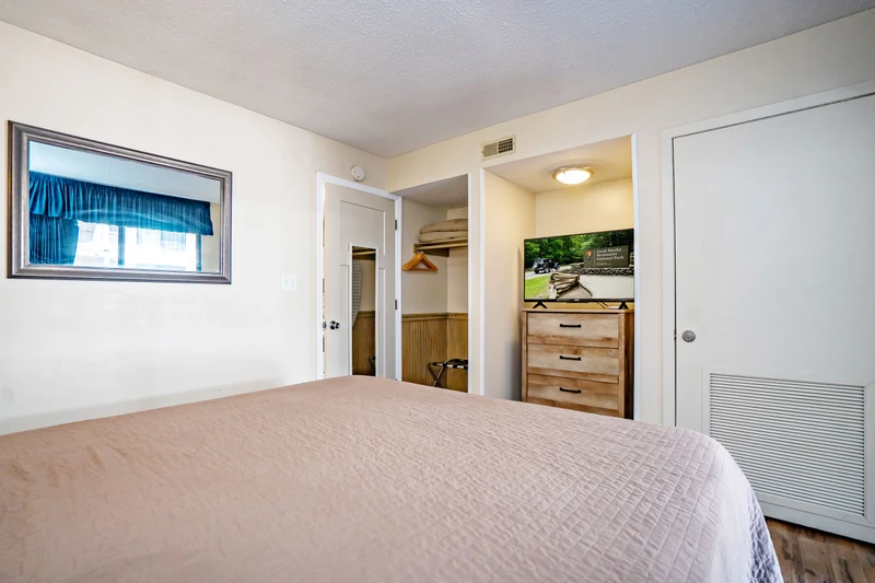 Your serene bedroom features a welcoming space to unwind, with a cozy bed, ample closet storage, and thoughtful touches like a mounted TV for your evening entertainment.