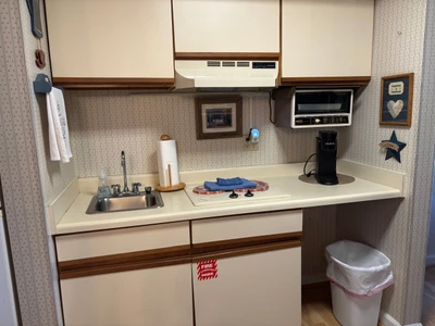 Your compact kitchenette has everything you need—sink, stovetop, microwave, and coffee maker—all neatly arranged for easy meal prep during your stay.