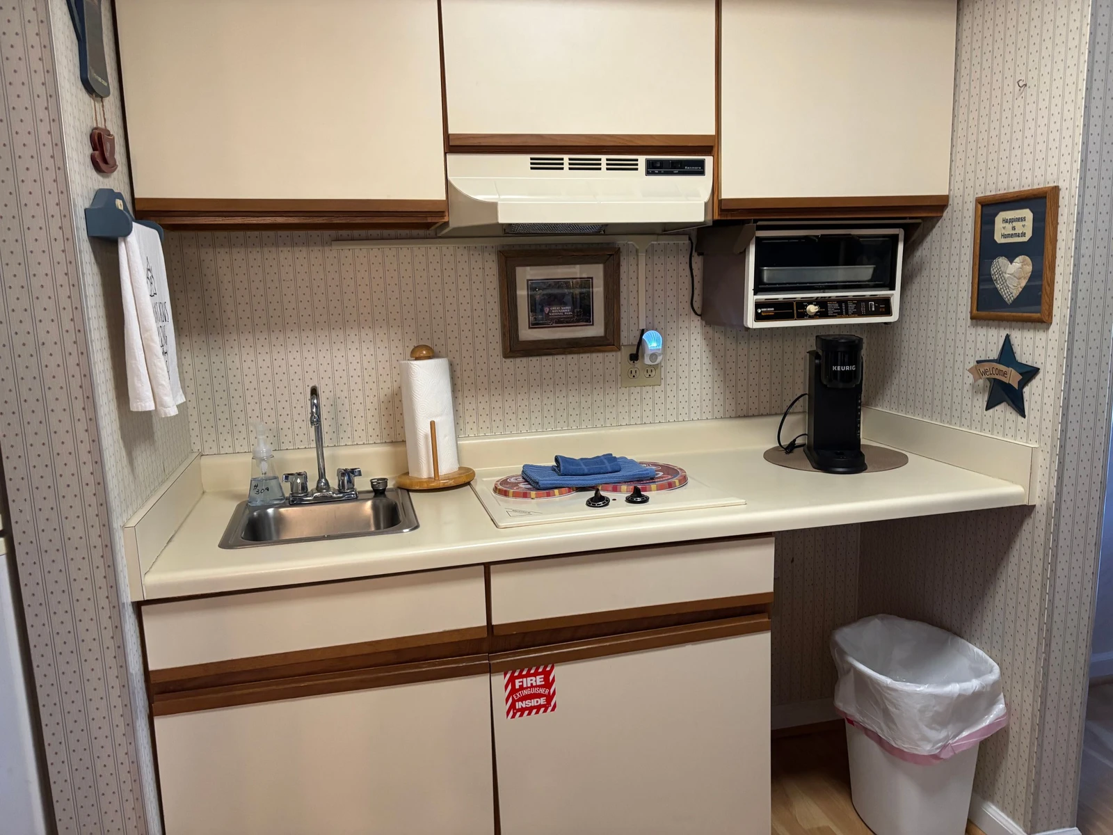 Your compact kitchenette has everything you need—sink, stovetop, microwave, and coffee maker—all neatly arranged for easy meal prep during your stay.